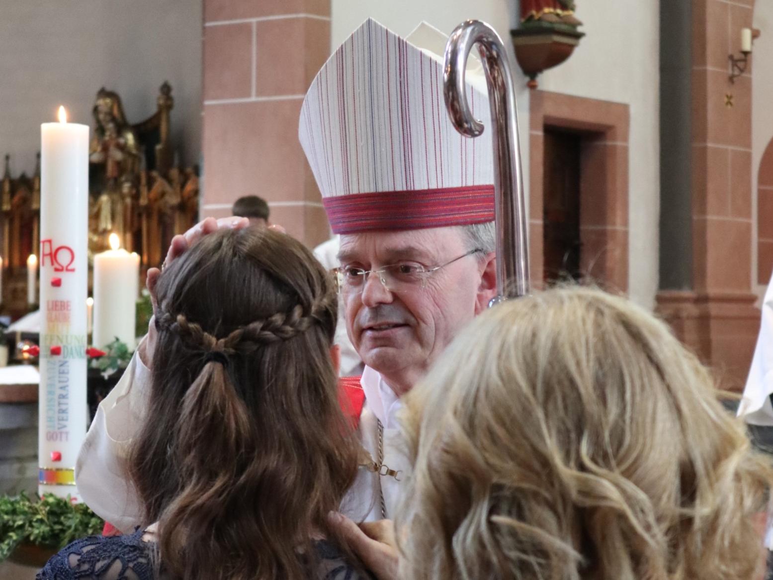 Weihbischof Brahm spendet einer jungen Frau das Sakrament der Firmung