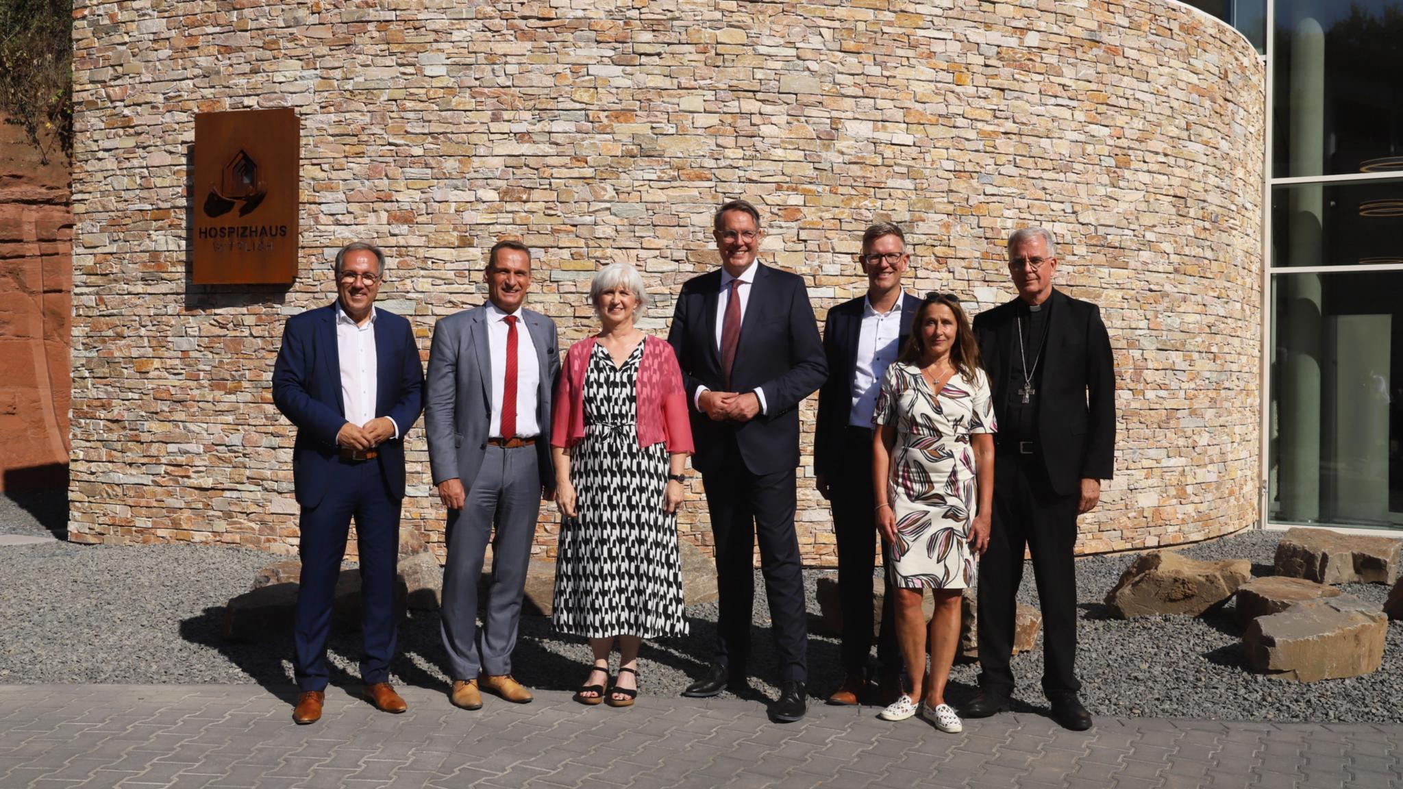 Vor dem Hospizhaus Wittlich (von links): Landrat Gregor Eibes, Bürgermeister Joachim Rodenkirch, Einrichtungsleiterin Cordula Bielemeier, Ministerpräsident Alexander Schweitzer, Geschäftsführer Thomas Buckler,  Schauspielerin Barbara Philipp, Weihbischof Jörg Michael Peters