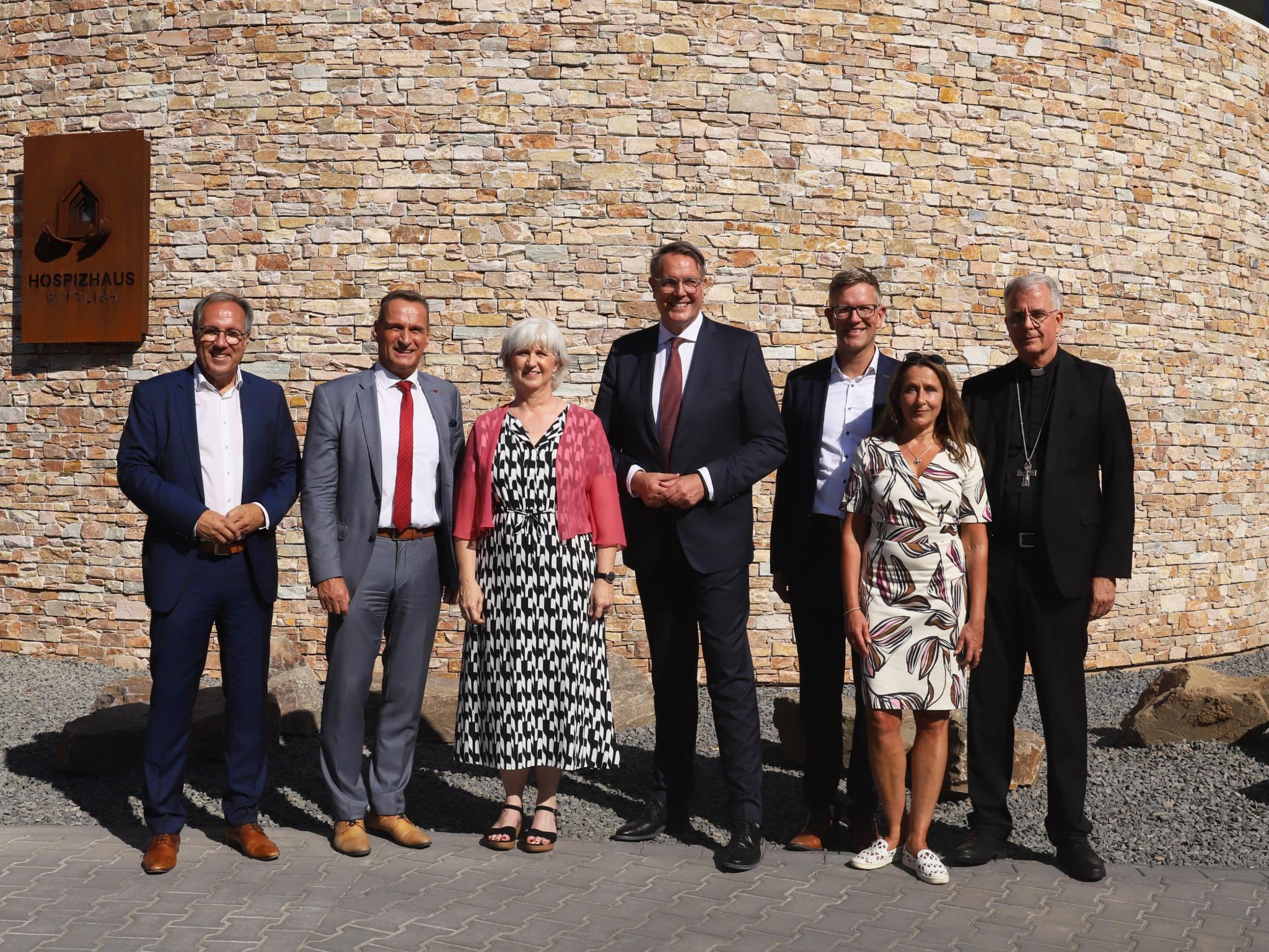 Vor dem Hospizhaus Wittlich (von links): Landrat Gregor Eibes, Bürgermeister Joachim Rodenkirch, Einrichtungsleiterin Cordula Bielemeier, Ministerpräsident Alexander Schweitzer, Geschäftsführer Thomas Buckler,  Schauspielerin Barbara Philipp, Weihbischof Jörg Michael Peters