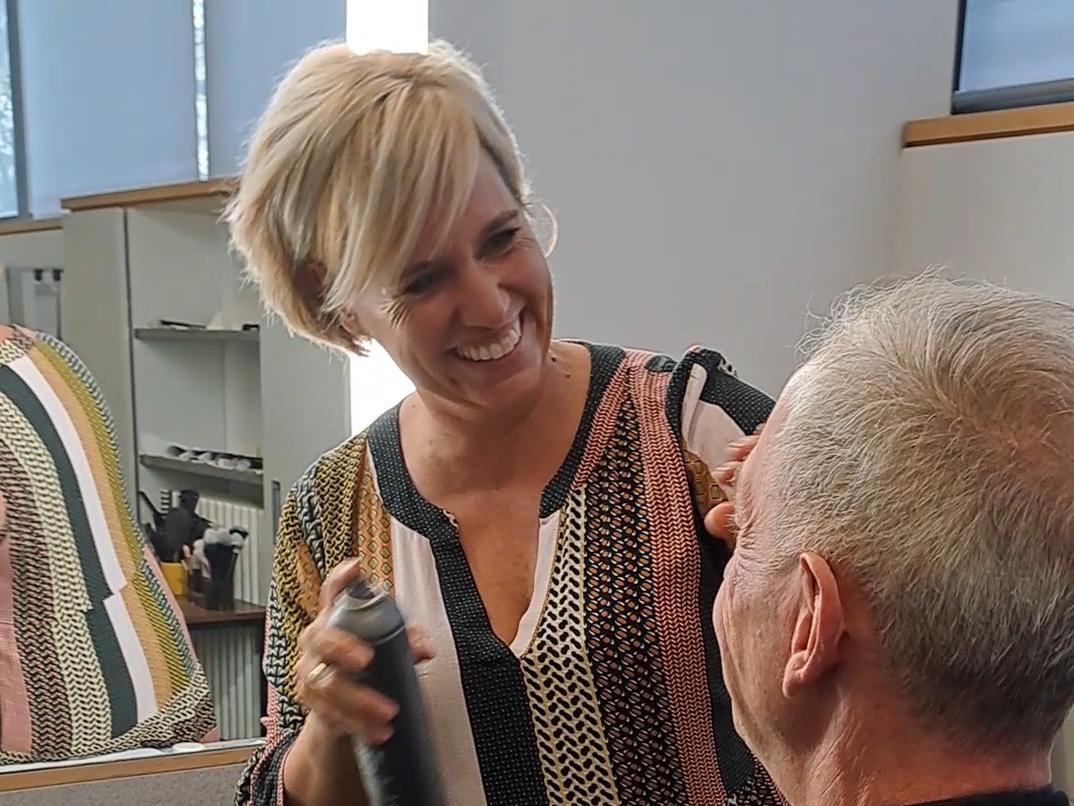 Maskenbildnerin Katja Texter benutzt das Make-up Setting Spray an Pfarrer Benedikt Welter