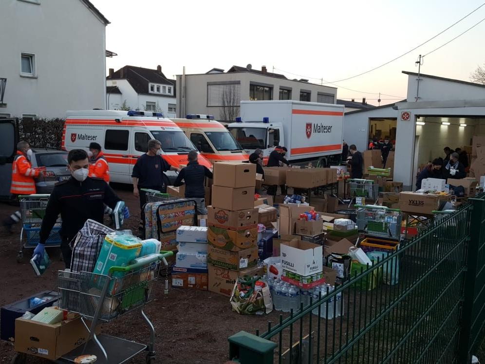 Mehrere Helfer der Malteser Trier vor einer großen LKW-Ladung an Sachspenden für die Ukraine.