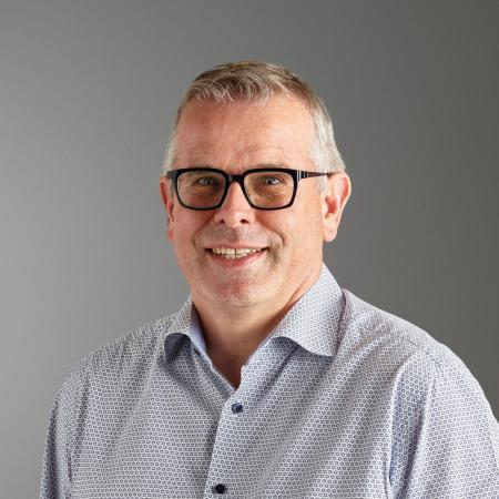 Portraitfoto von Christoph Morgen. Ein Mann mittleren Alters mit schwarzer Brille und kurzen Haaren schaut in die Kamera.