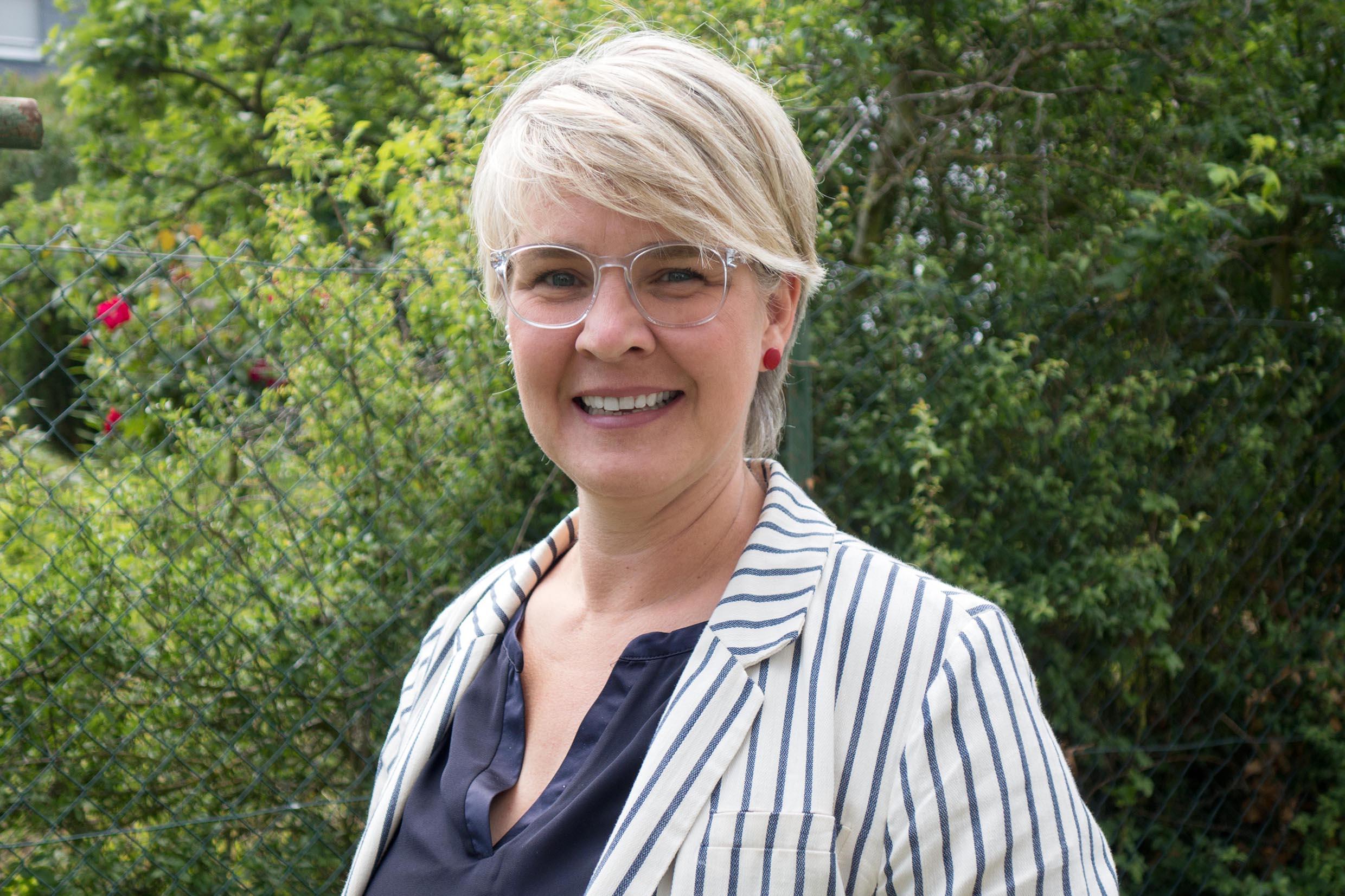 Portraitfoto einer Frau mit Brille und kurzen Haaren