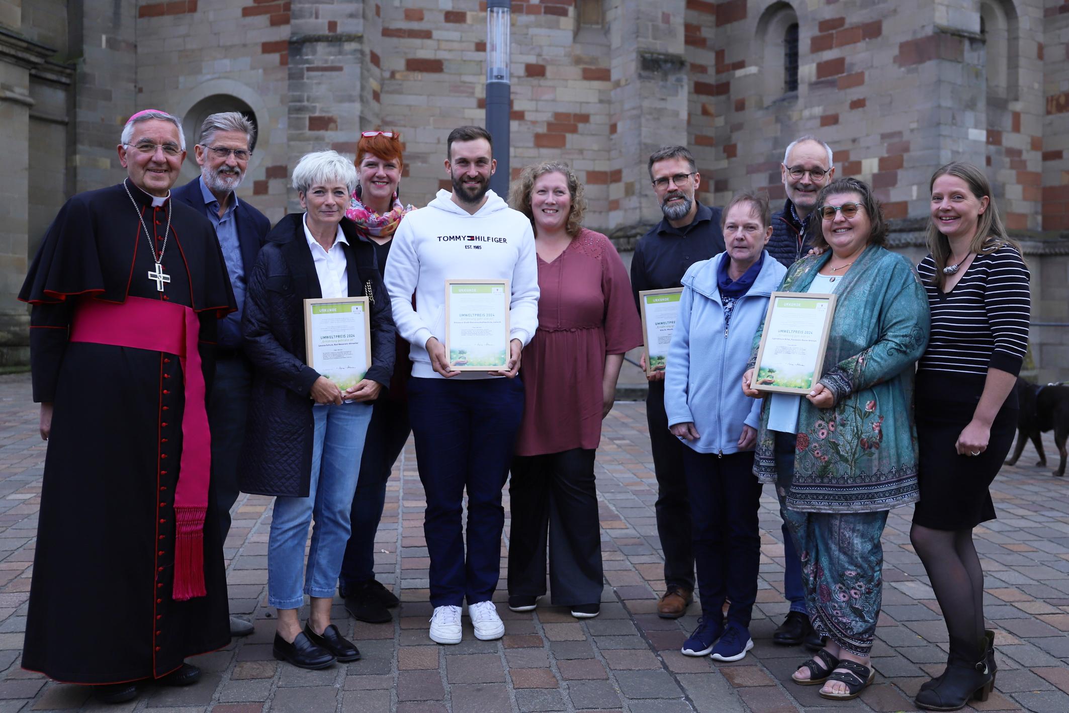 Der emeritierte Weihbischof Franz Josef Gebert (links) und Mitglieder der DKU gratulieren den Siegerinnen und Siegern des Umweltpreises des Bistums Trier 2024.