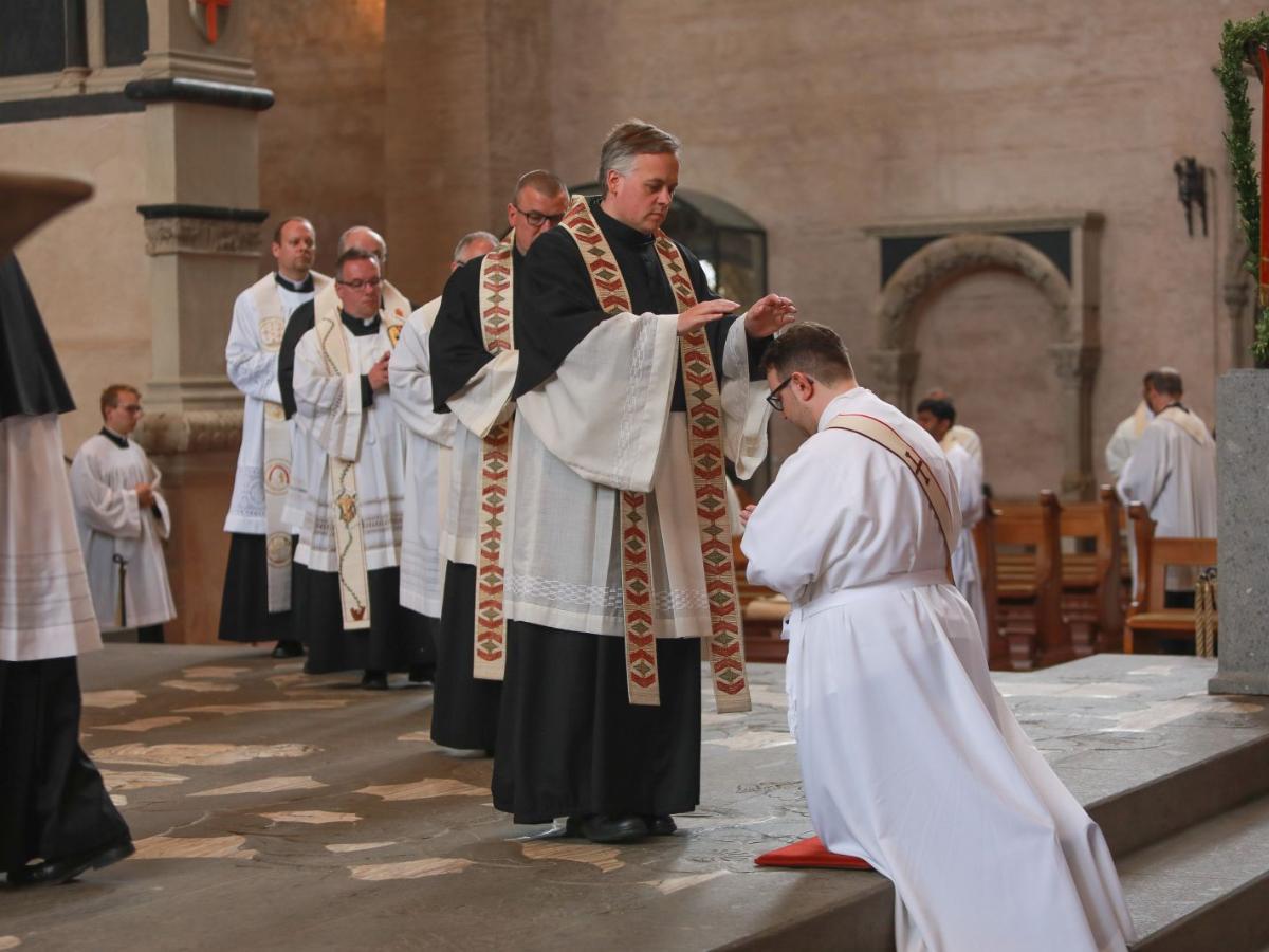 Ein zukünftiger Priester kniet während seiner Weihe im Trierer Dom
